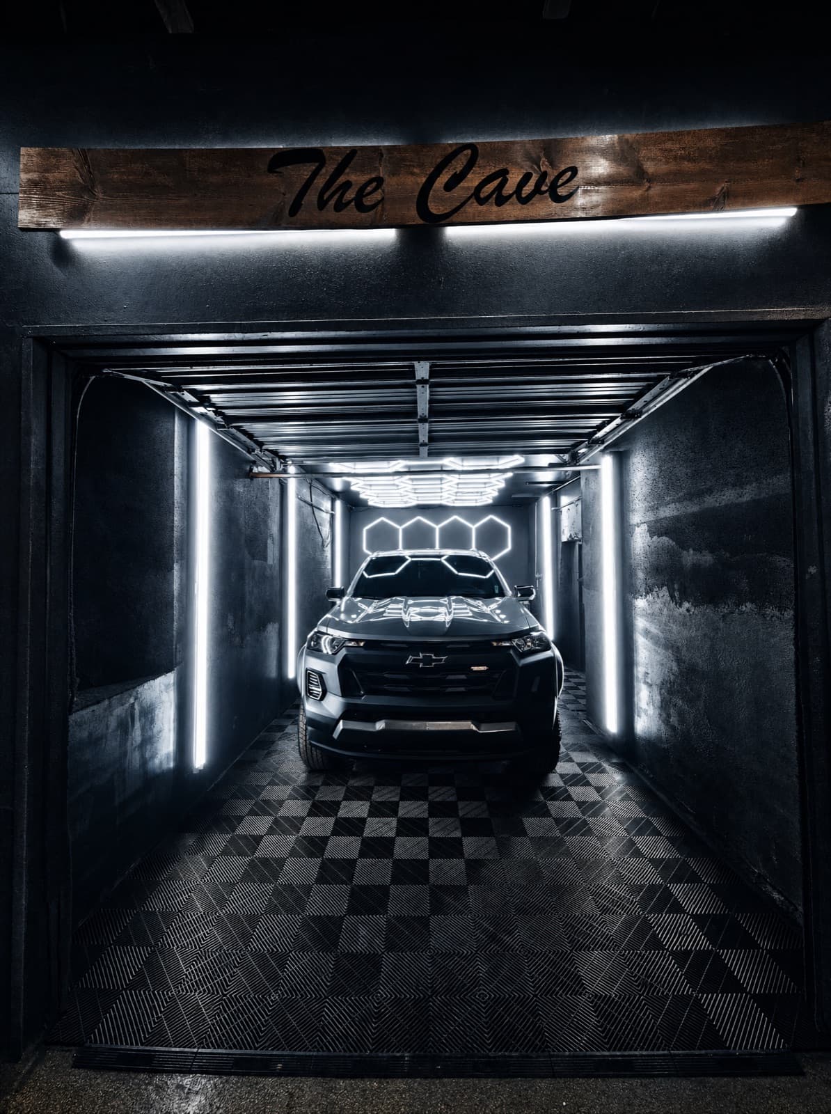 Blacked-out Chevrolet truck lit dramatically inside the studio's signature room, The Cave